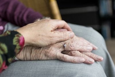 Hand einer älteren Frau wird gehalten