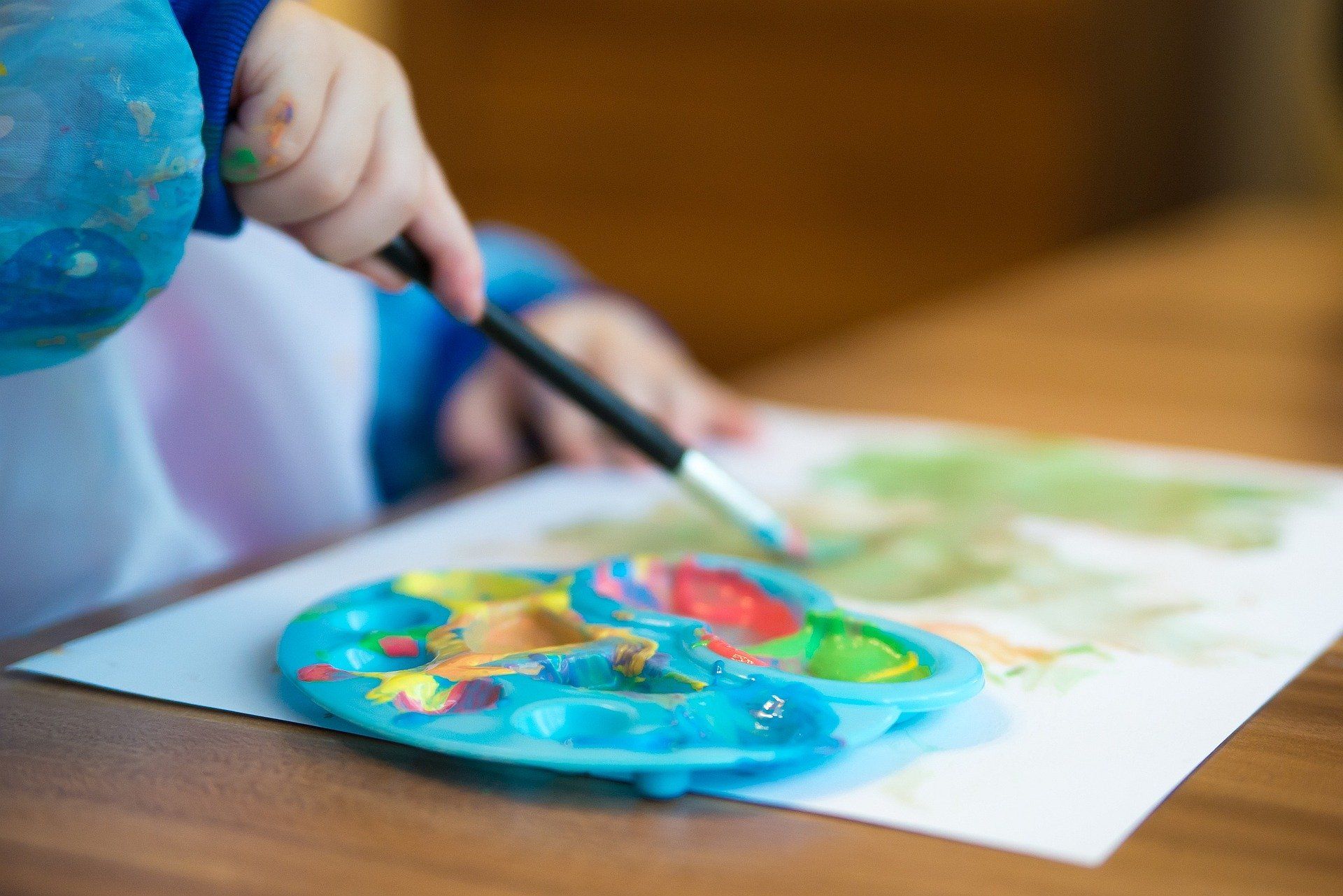 Kind malt mit bunten Wasserfarben