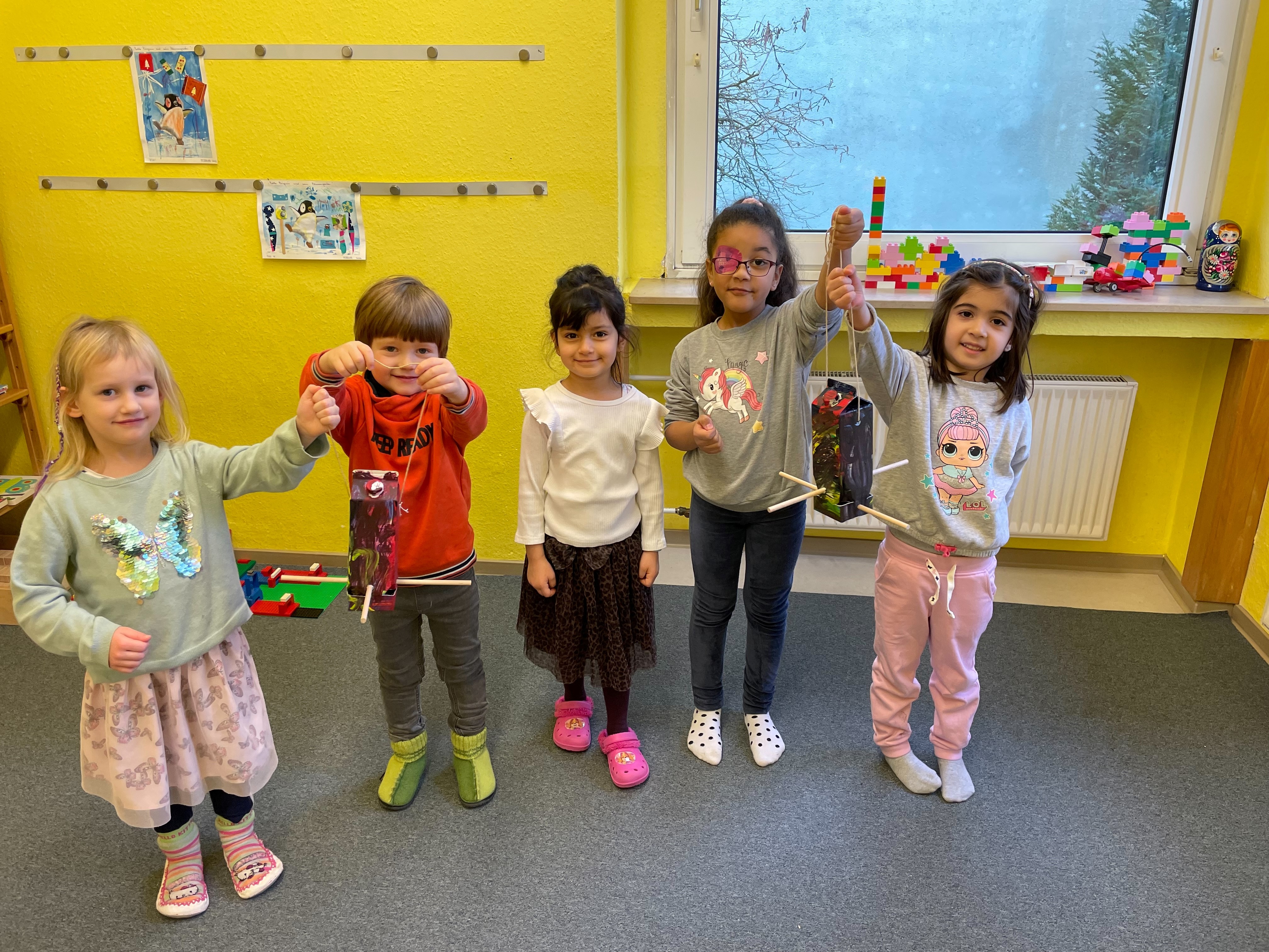 Kita-Kinder mit Futterhäuschen