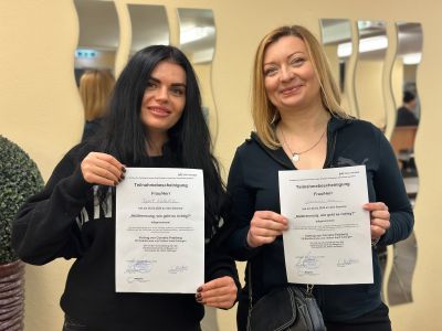 Zwei Fraue halten ein Zertifikat in der Hand