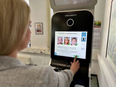 Eine Person bedient den Touchscreen des Fototerminals