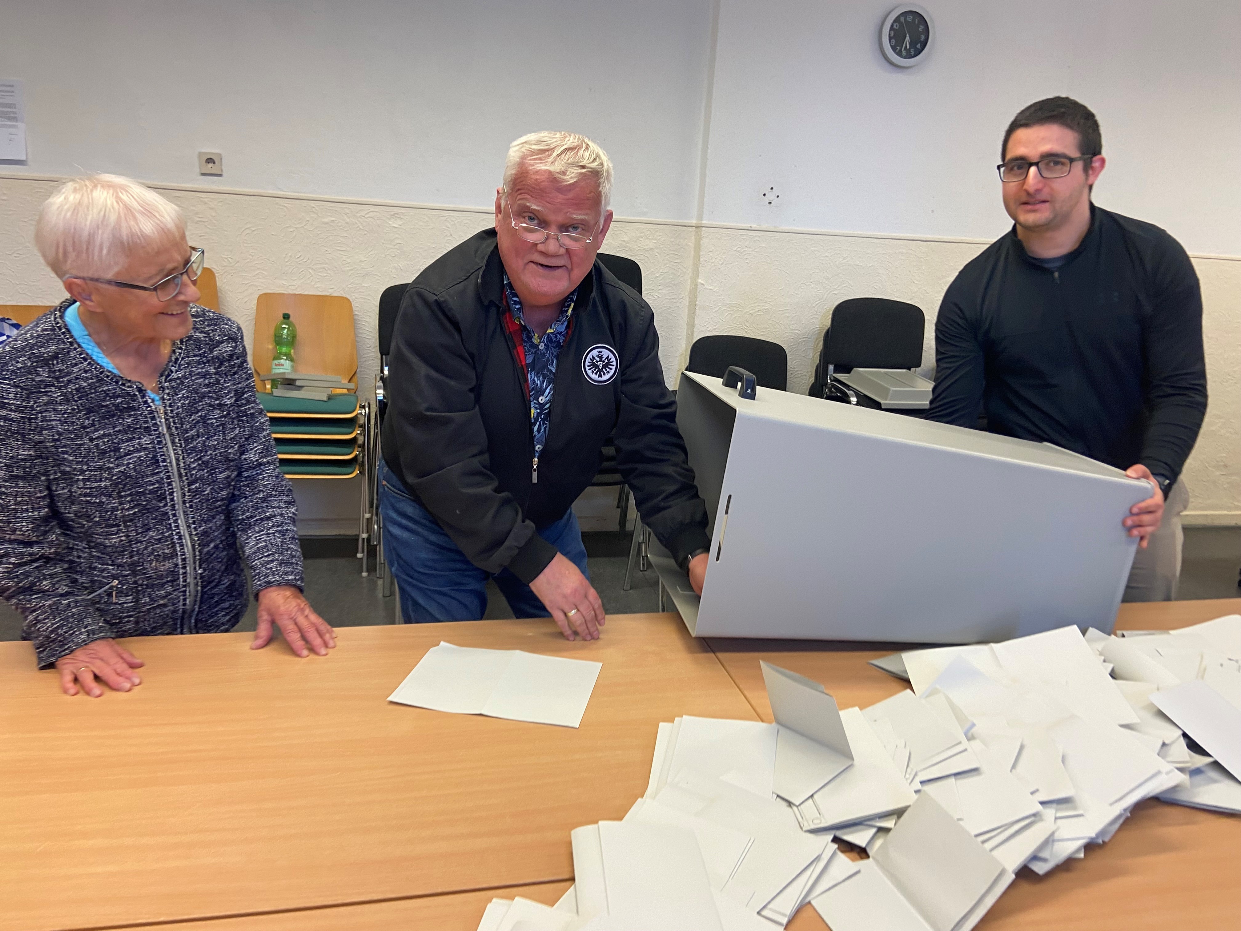 Menschen mit Wahlurne aus der Stimmzettel auf einen tisch fallen