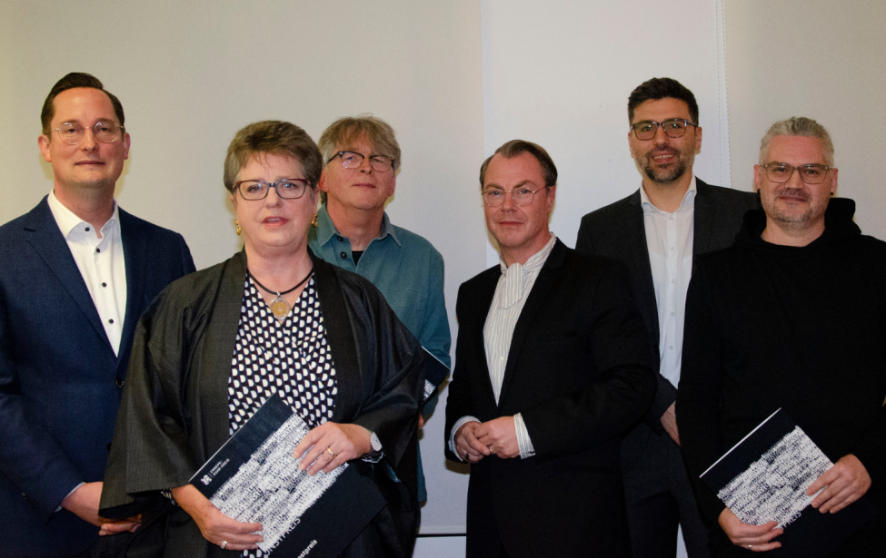 Fotografie von sechs Personen vor einer weißen Wand