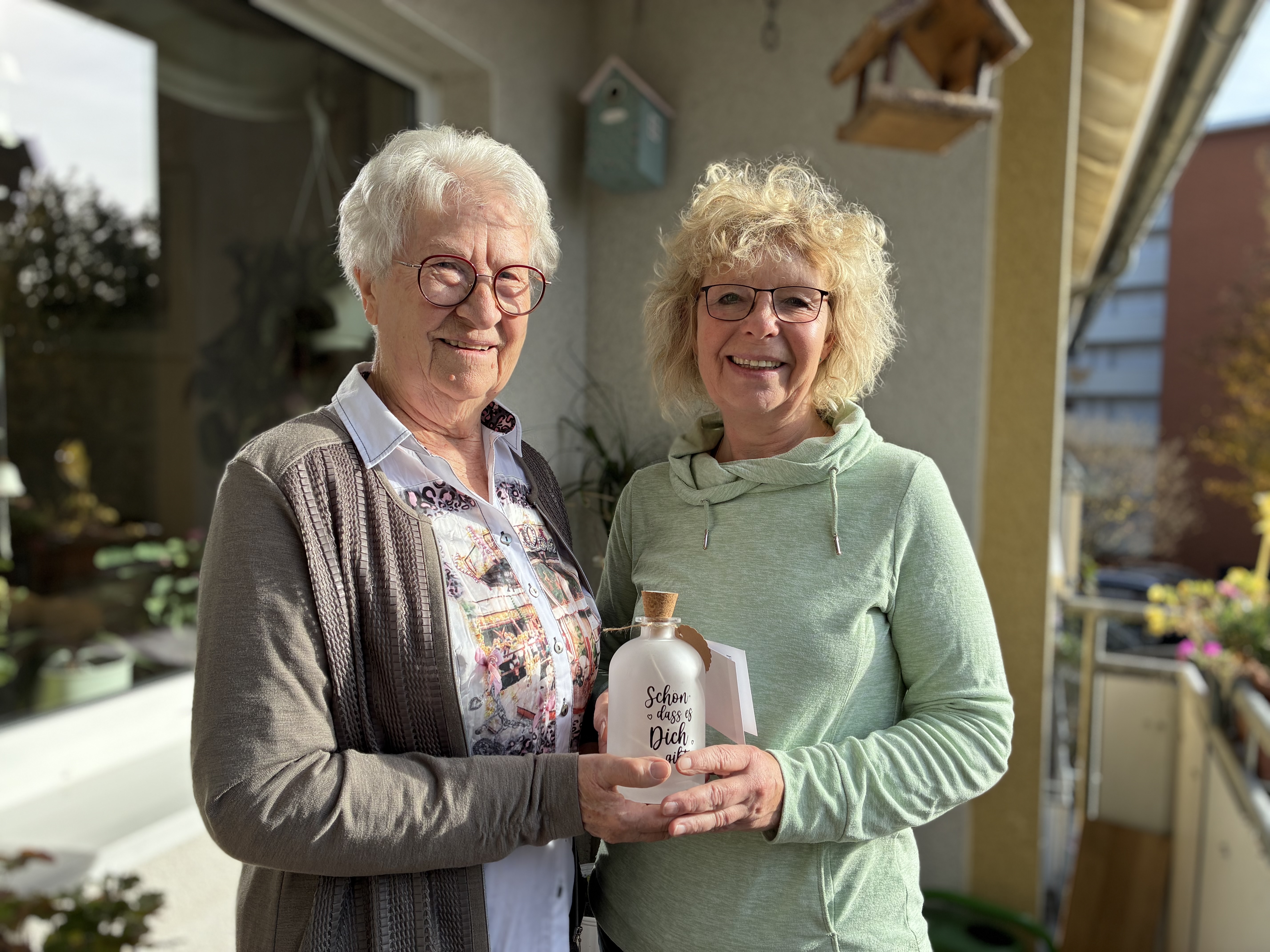 Fotografie von zwei Personen, die gemeinsam das Geschenk in der Hand halten