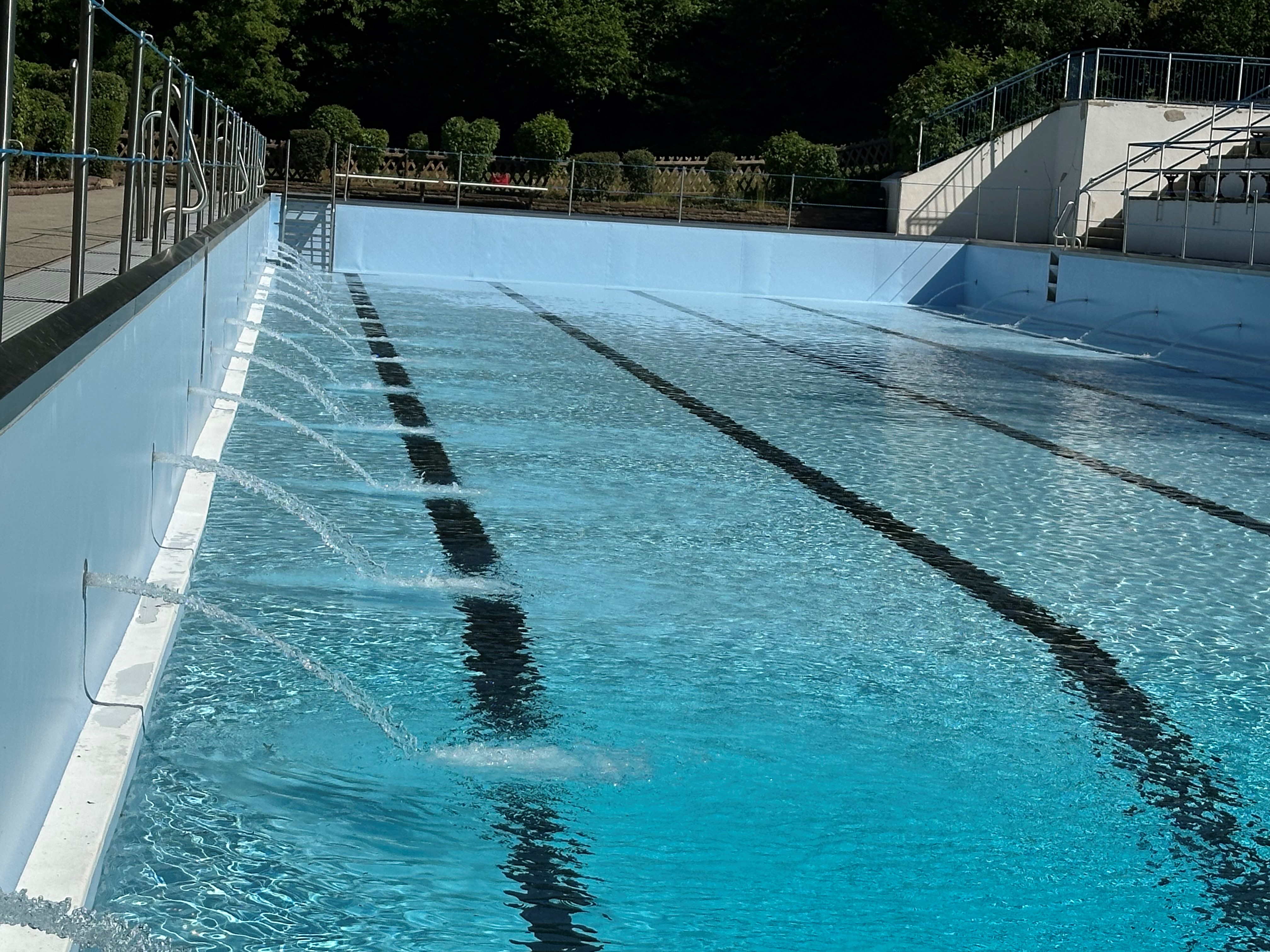 Becken eines Freibades in das Wasser eingelassen wird