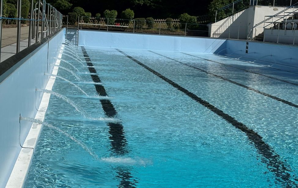 Becken eines Freibades in das Wasser eingelassen wird