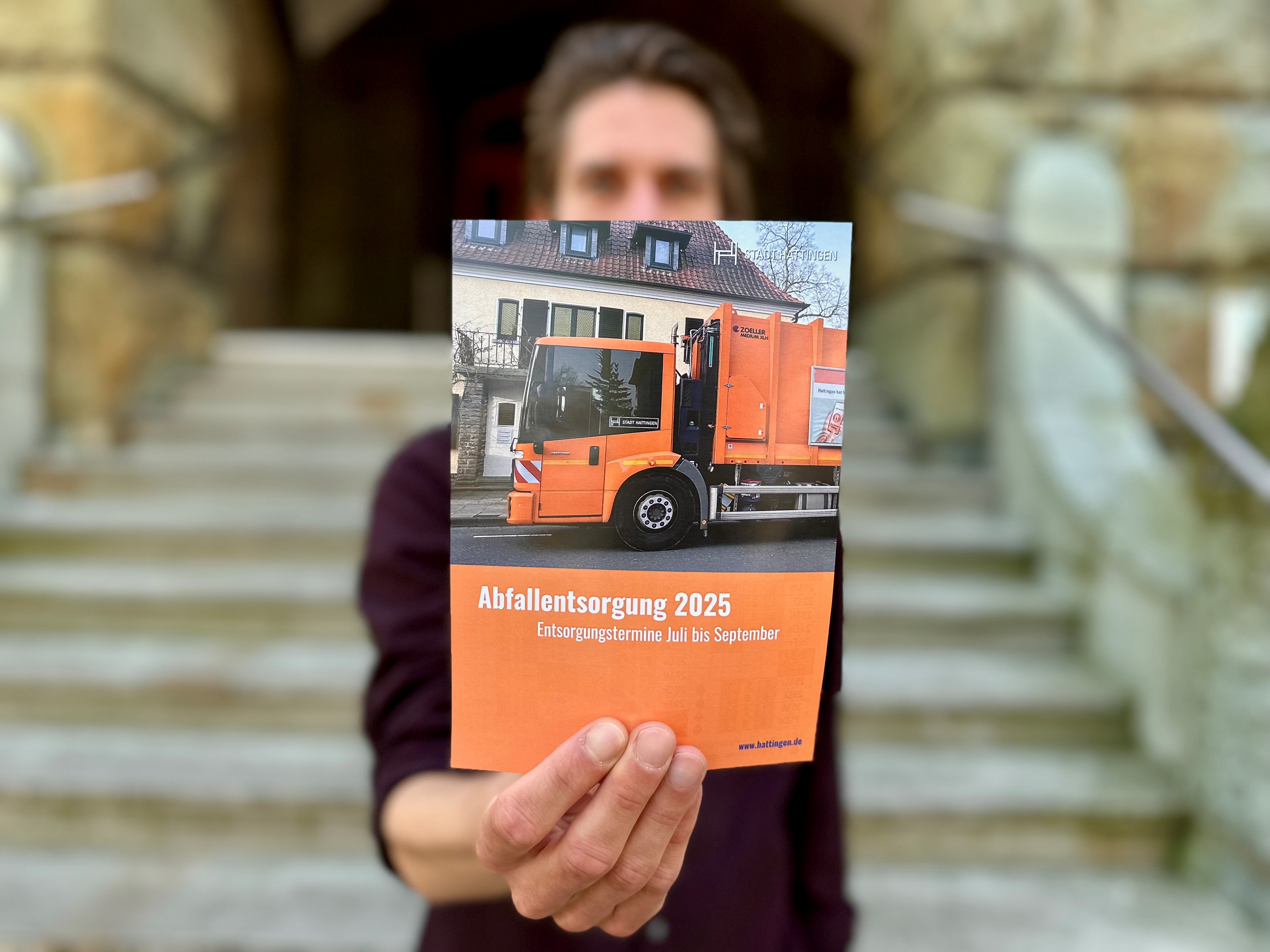 Eine Person hält den Flyer in den Händen hoch