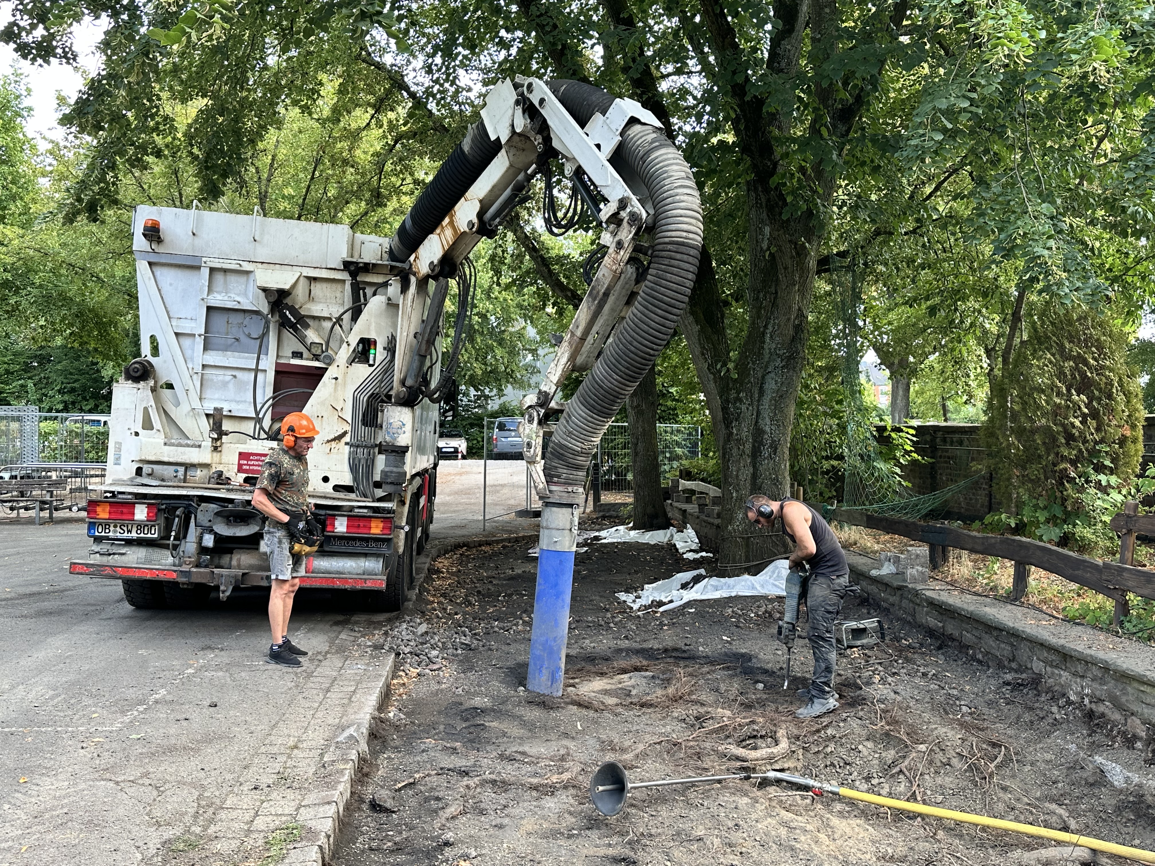 Saug-Bagger an der Grundschule Heggerfeld ist im Einsatz um die Baumscheiben zu vergrößern. 