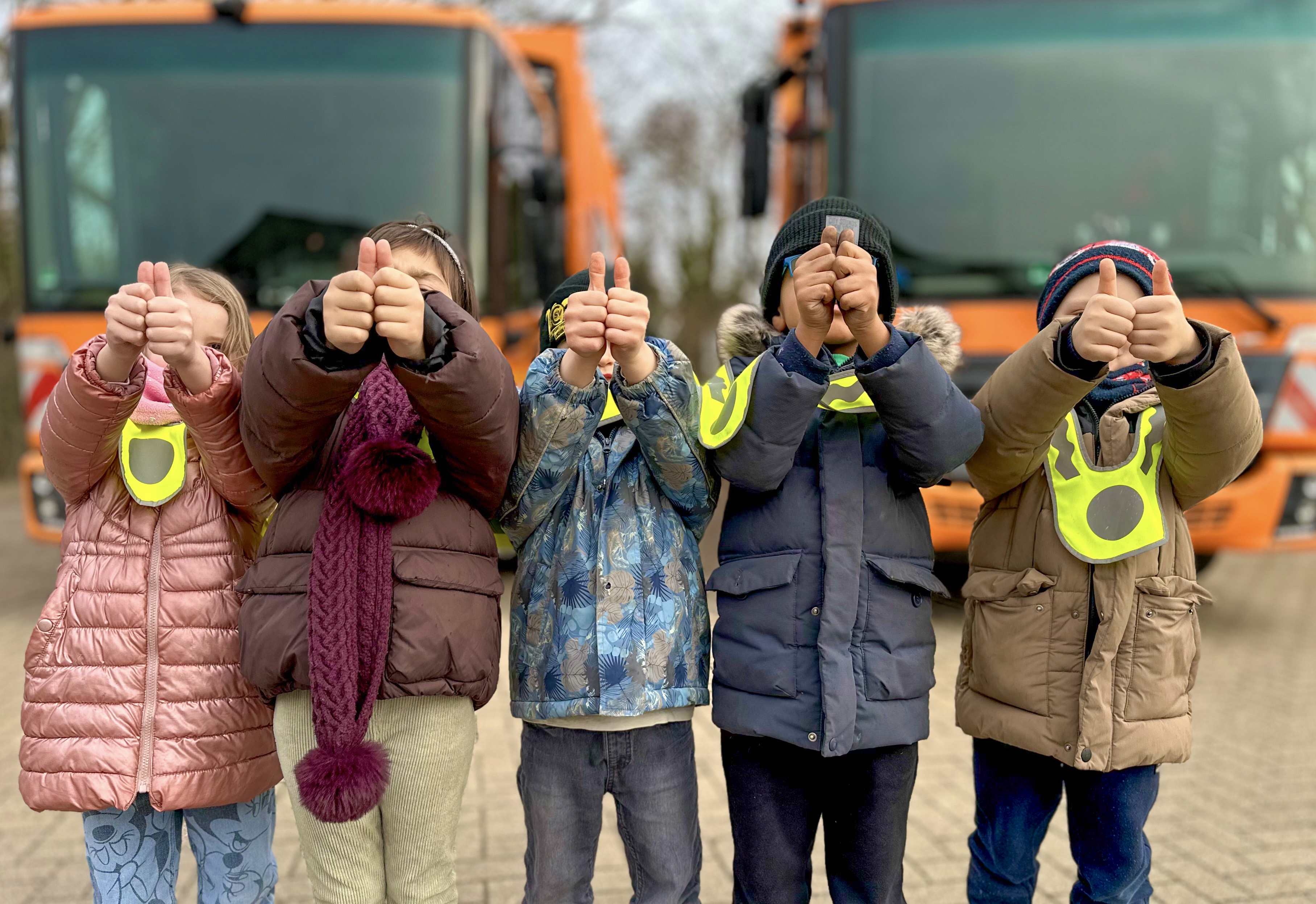Fotografie von fünf Kinder, die ihre Daumen vor das Gesicht halten
