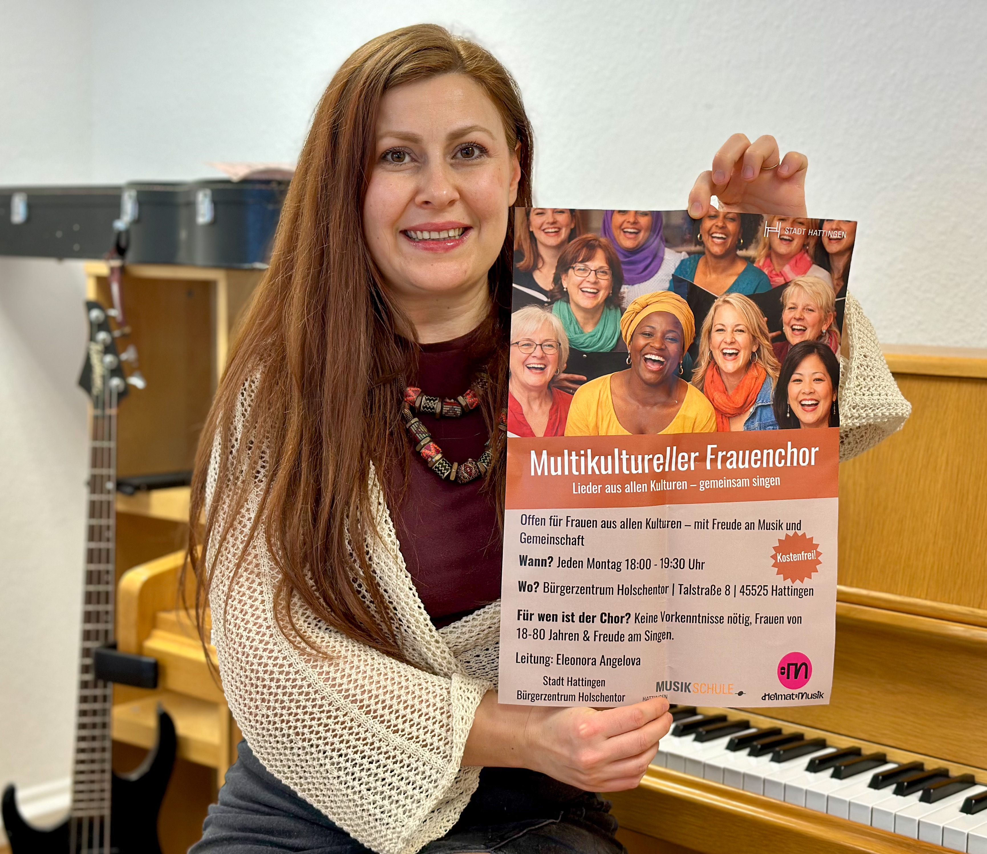 Fotografie von der Chorleiterin, die ein Plakat in der Hand hält