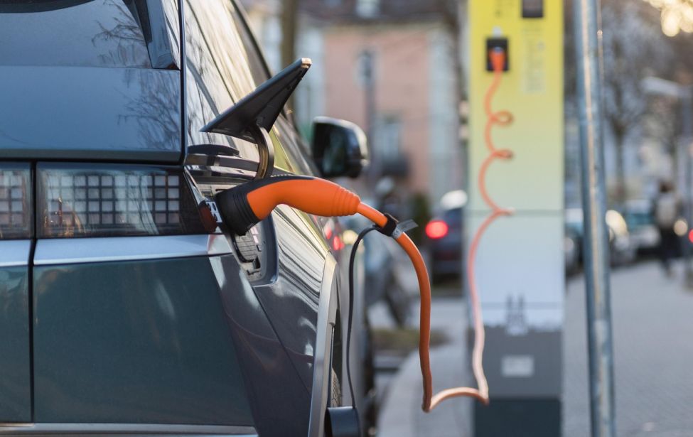 Fotografie eines Autos, dass an einer Ladestation angeschlossen ist