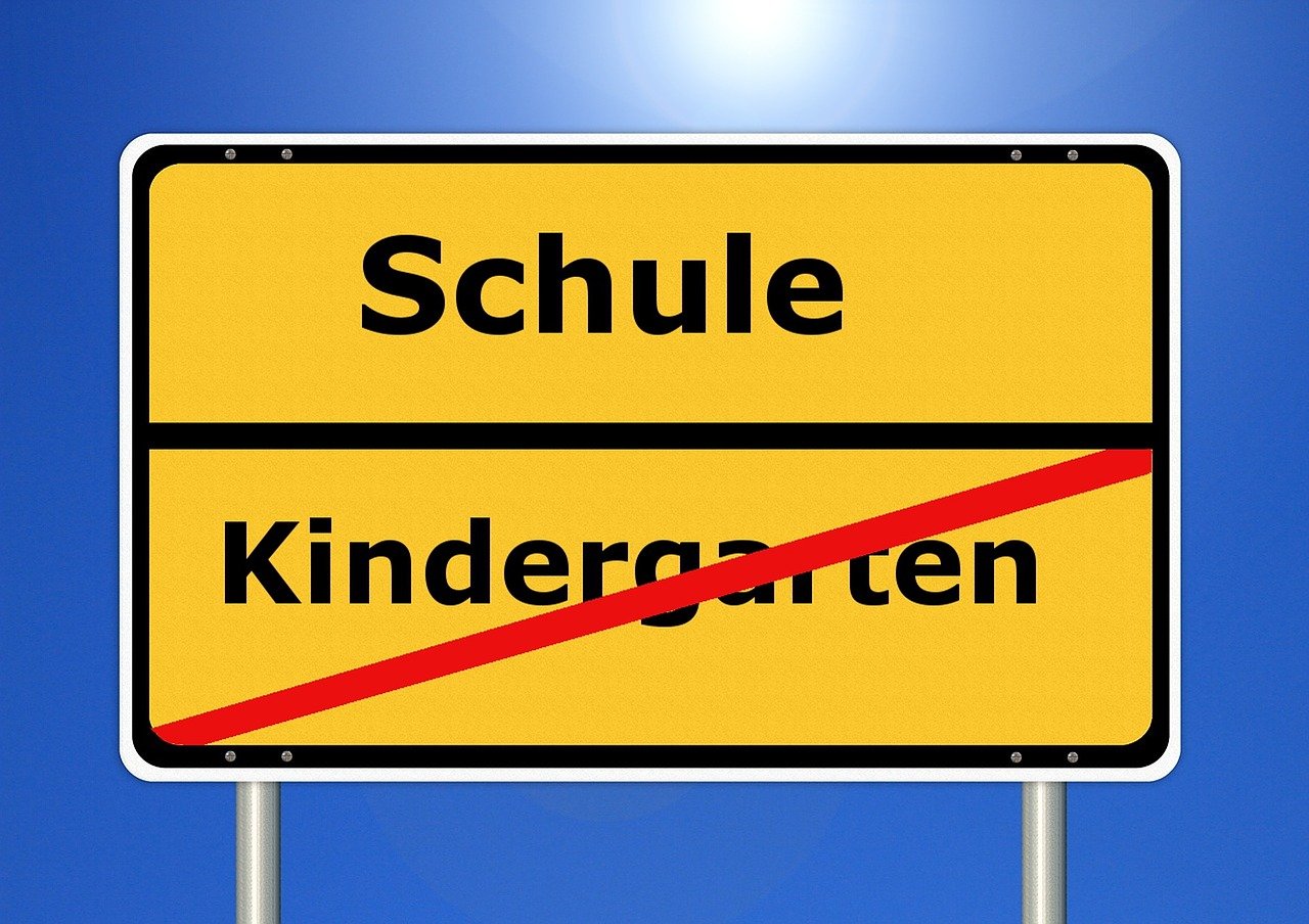 Bild von Schild, auf dem Schule steht und Kindergarten druchgestrichen