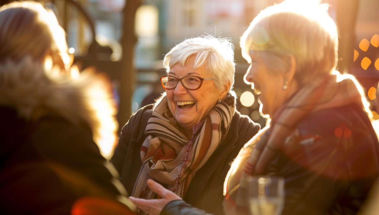 Fotografie einer Gruppe von Seniorinnen, die sich lachend unterhält