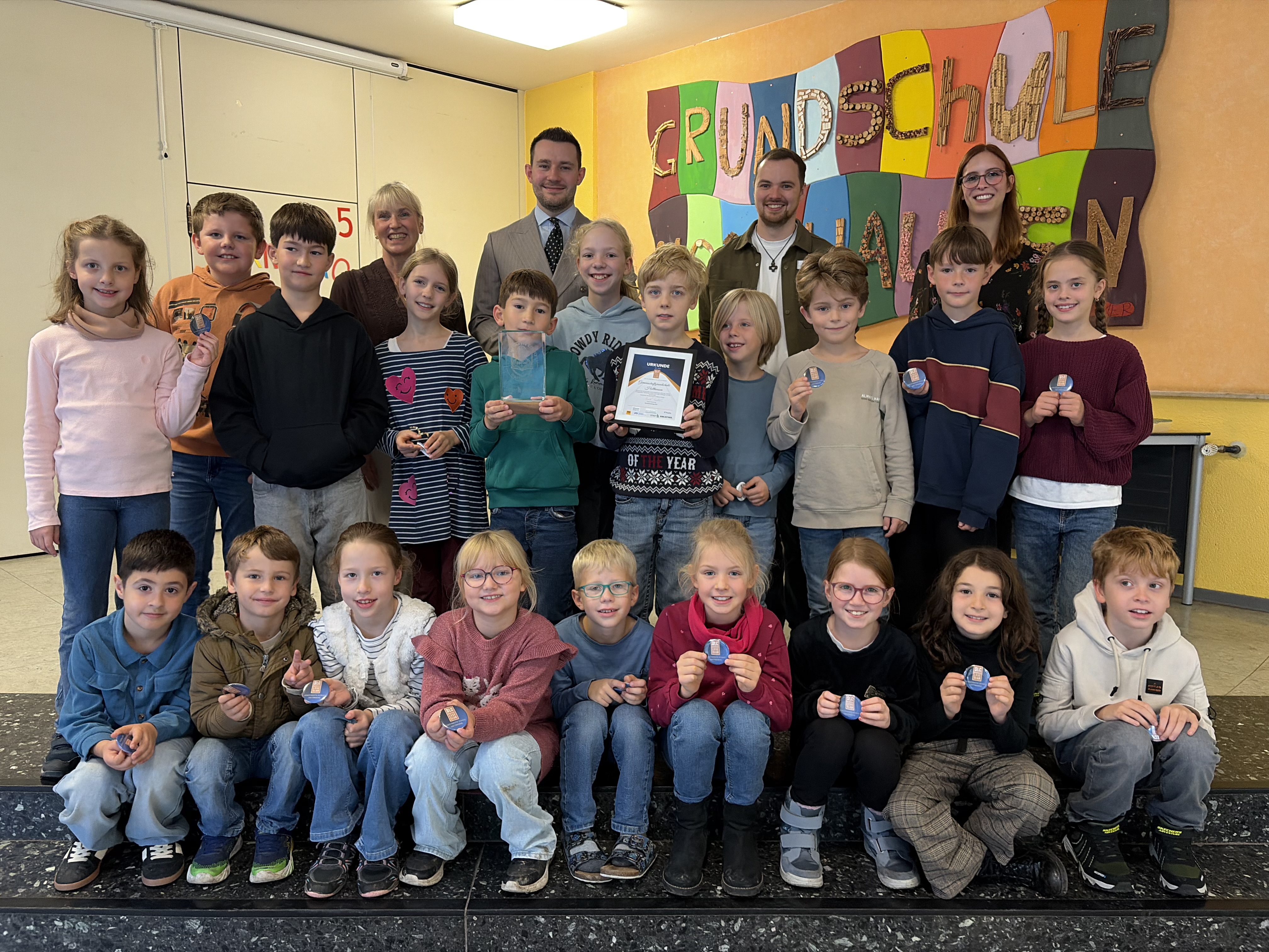 Schülerinnen und Schüler der Grundschule Holthausen erhalten einen Pokal als lesestärkste Schule. 