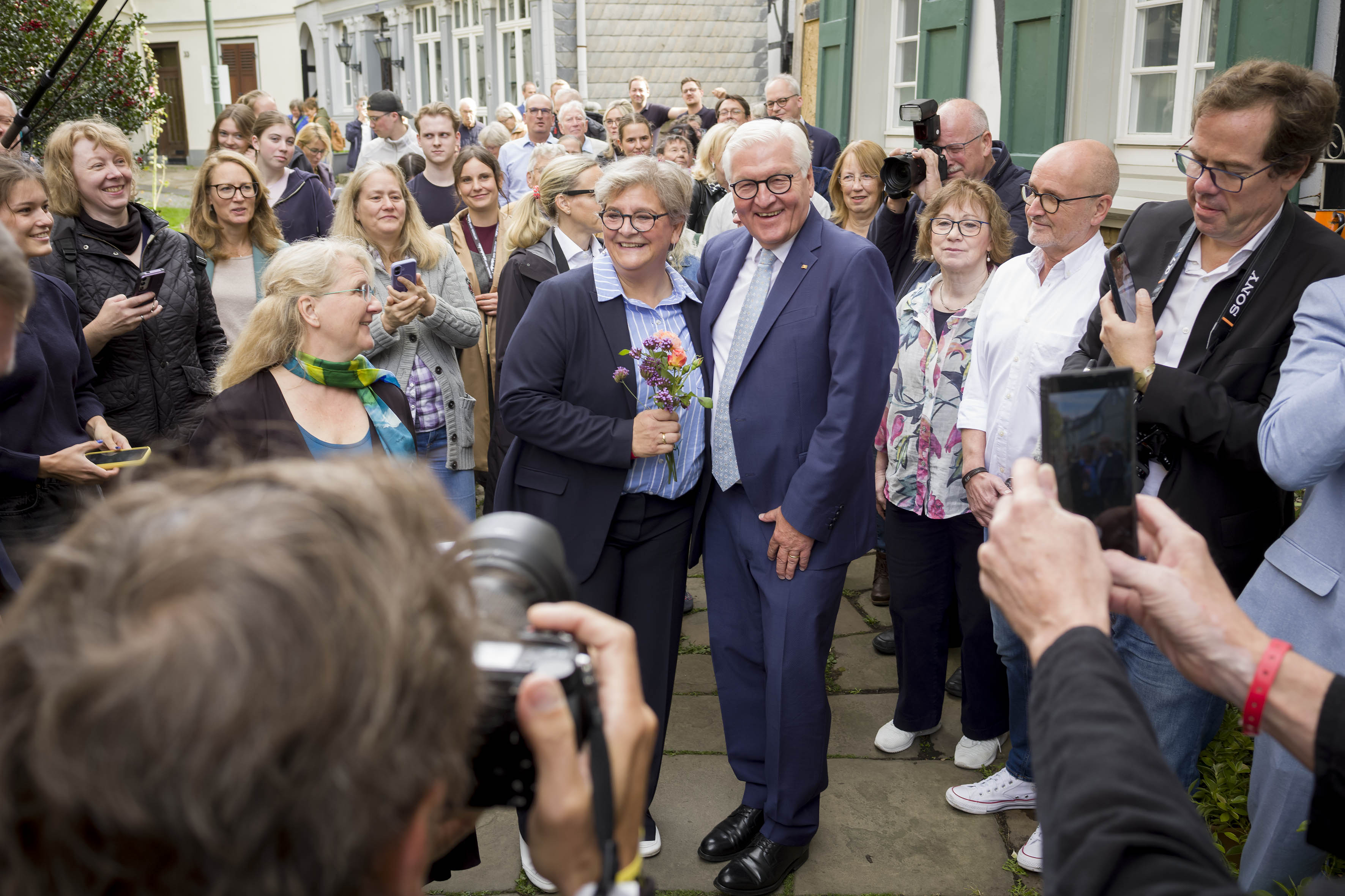 Bürgermeisterin auf dem Kirchplatz mit Bundespräsident umrigt von vielen Menschen
