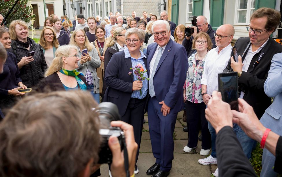 Bürgermeisterin auf dem Kirchplatz mit Bundespräsident umrigt von vielen Menschen
