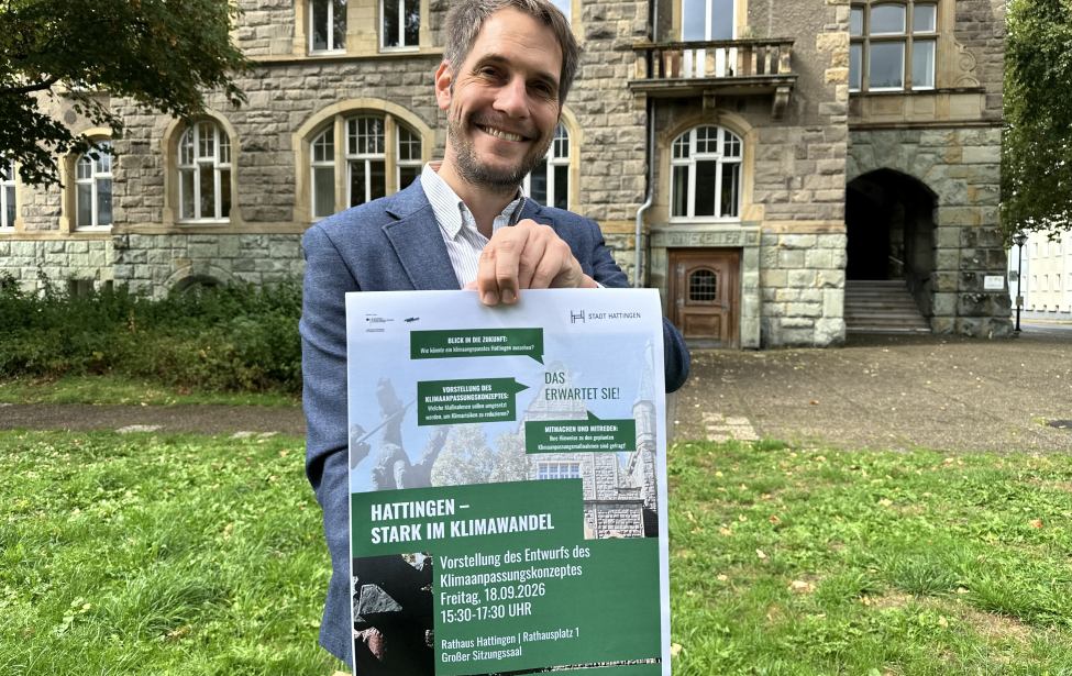 Klimaanpassungsmanager Matthias Falke mit dem Plakat zur Informationsveranstaltung vor dem Rathaus 