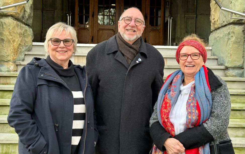 Drei Personen stehen vor der Rathaustreppe
